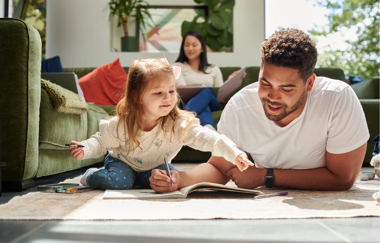 Father helps daughter with homework at home at Halstead Chantilly